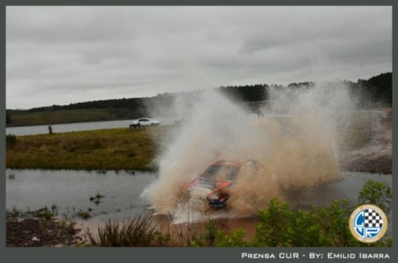 Auto de rally compitiendo mientras pasa por el agua Auto de rally compitiendo mientras pasa por el agua