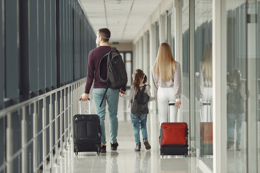 Familia en aeropuerto, con sus máscaras de protección contra el Coronavirus