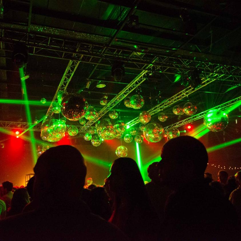 Noche de la Nostalgia en una discoteca. Luces de colores con público bailando.