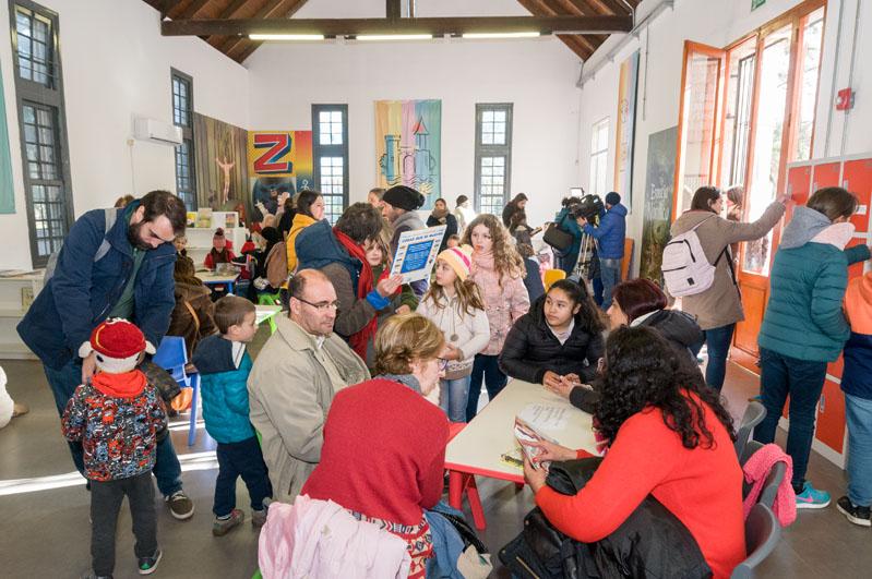 Niños, padres y abuelos leyendo libros en la biblioteca del Castillo del Parque Rodó