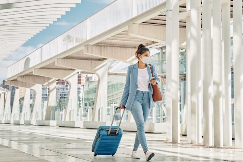 Mujer con equipaje en aeropuerto durante la pandemia Mujer con equipaje en aeropuerto durante la pandemia