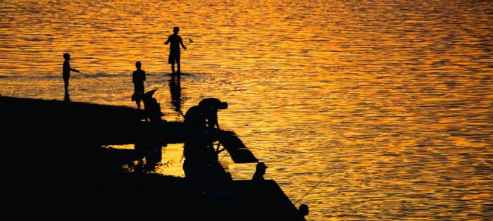Atractivo turístico Personas pescando en un atardecer junto al río en Salto