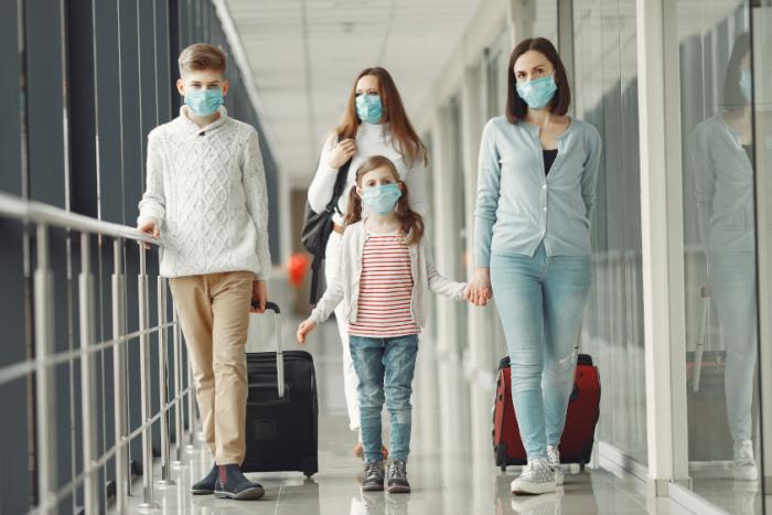 Familia en aeropuerto, con sus máscaras de protección contra el Coronavirus Familia en aeropuerto, con sus máscaras de protección contra el Coronavirus