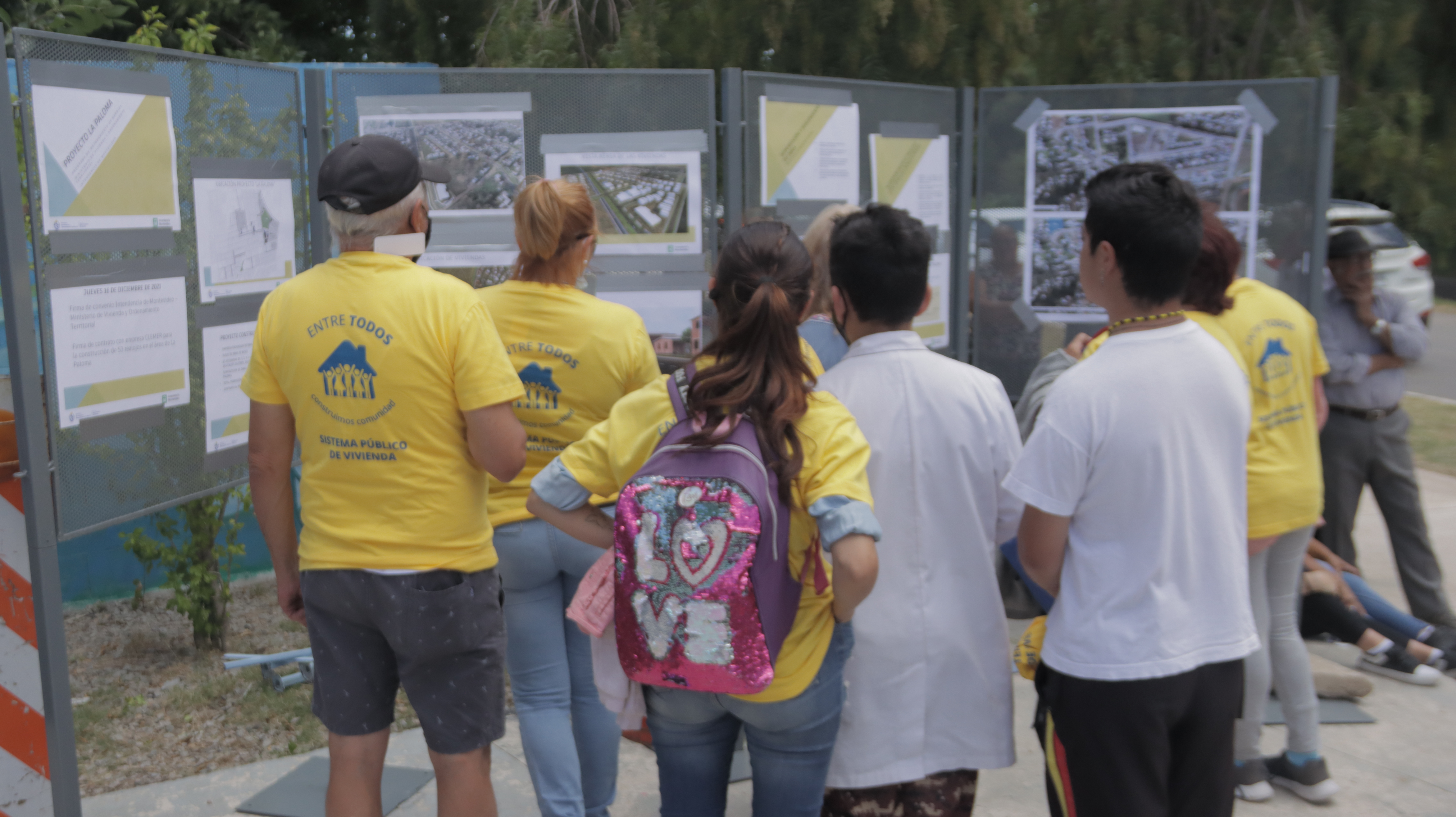 vecinos de La Paloma observando la obra en carteles con fotografías