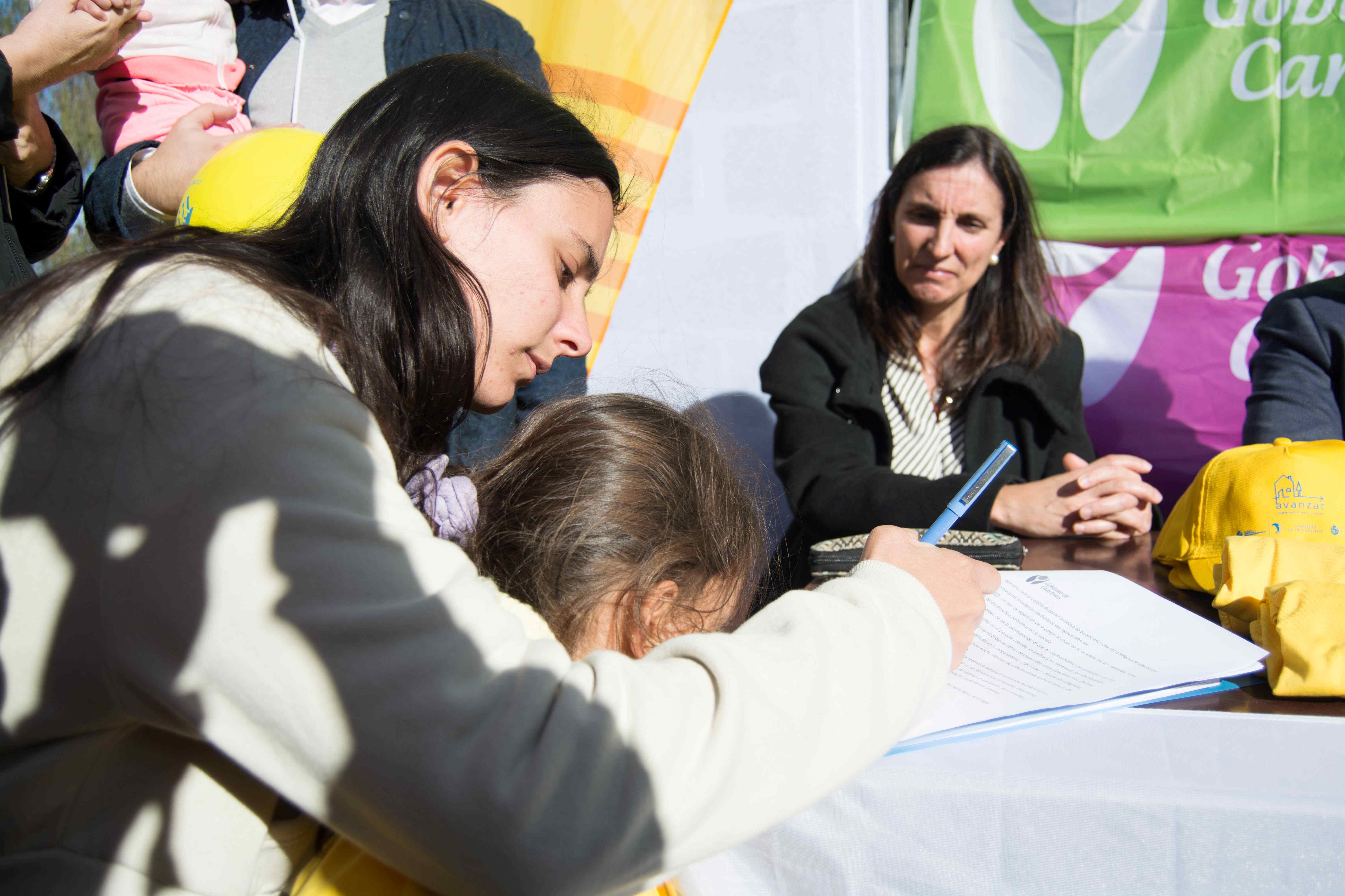 Familia firmando entrega de viviendas