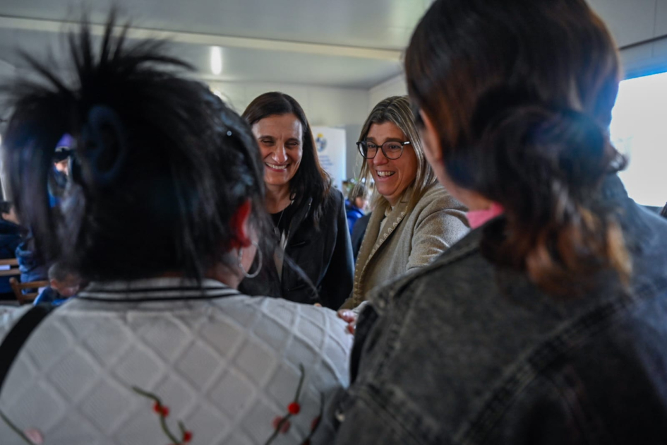 vecinas de espalda y Ministra y Coordinadora de frente sonriendo 
