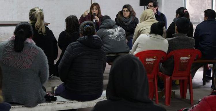 Viviendas inauguradas Autoridad dando una charla y varias personas sentadas