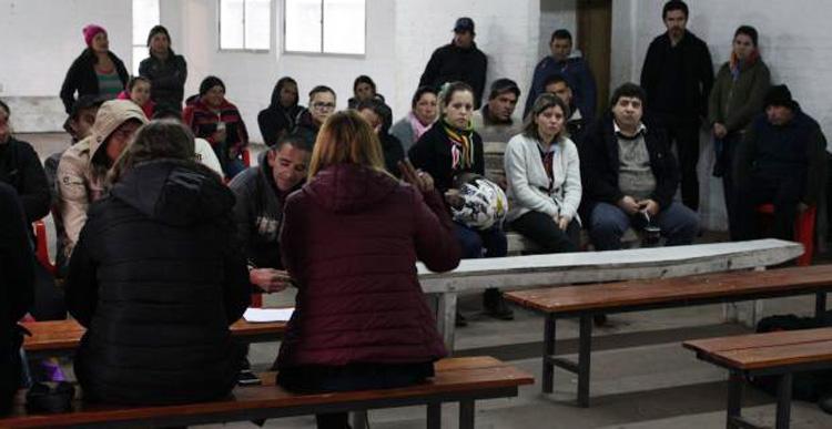 Viviendas inauguradas Autoridad dando una charla y varias personas sentadas
