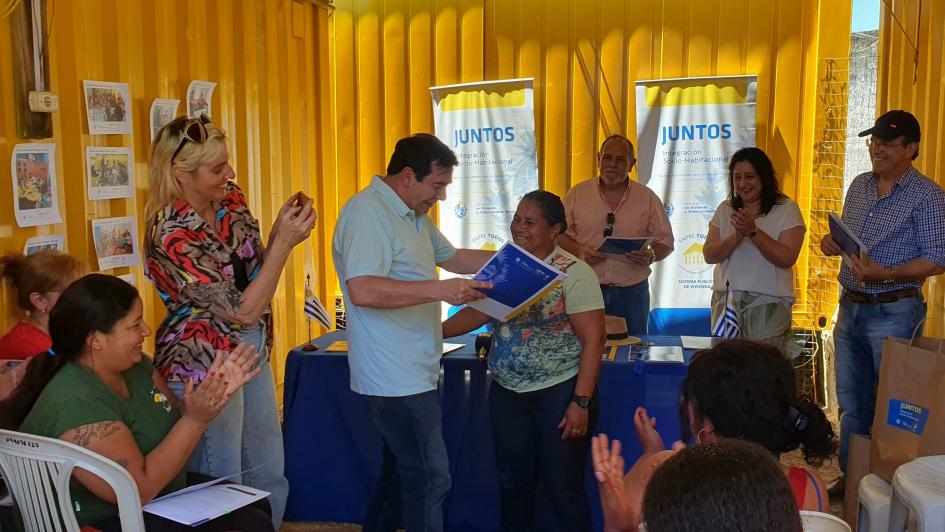 Coordinador general Rody Macías entrega los documentos del acuerdo particular a una participante