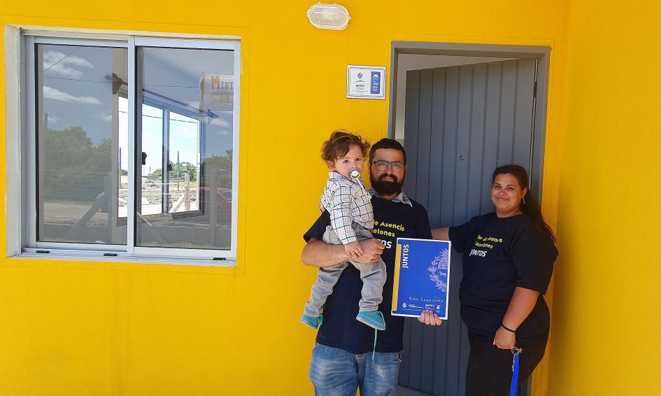 Familia participante en la entrada de su nueva casa