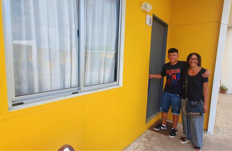 Familia participante de Juntos en la puerta de su nueva vivienda Familia participante de Juntos en la puerta de su nueva vivienda