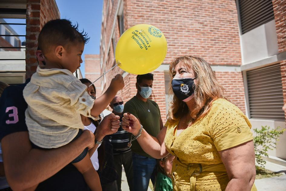 Ministra y un niño beneficiario sostienen un globo Ministra y un niño beneficiario sostienen un globo