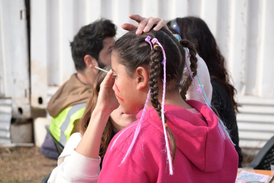 Animadora pintando la cara de una niña 27 aniversario del Barrio Cotravi