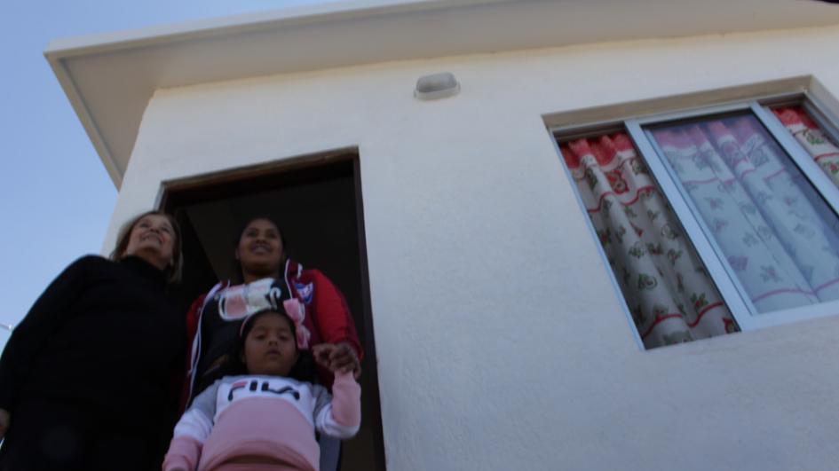 8 familias una familia en la puerta de su nueva vivienda