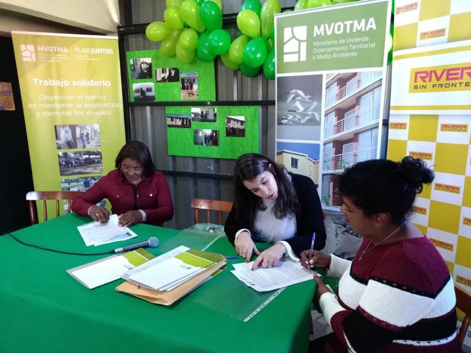 8 familias 3 personas firmando documentación