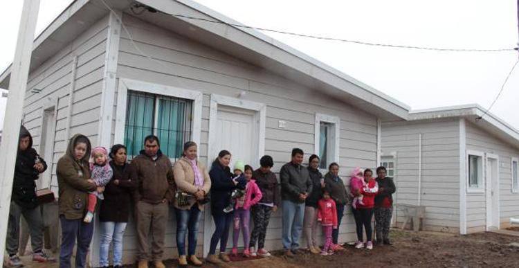 Viviendas inauguradas Varias familias paradas frente a una vivienda