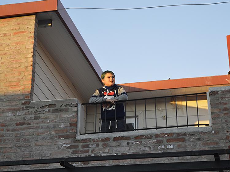 La conquista de un derecho - 32 familias cooperativistas inauguraron sus viviendas en Mercedes Foto de un niño en el balcón de una vivienda