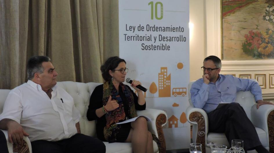 Living hablando Ayala a su izquierda Vidalín y a su derecha Arím. Atrás se ve un banner que dice 10 años de la Ley de ordenamiento Territorial y Desarrollo Sostenible 