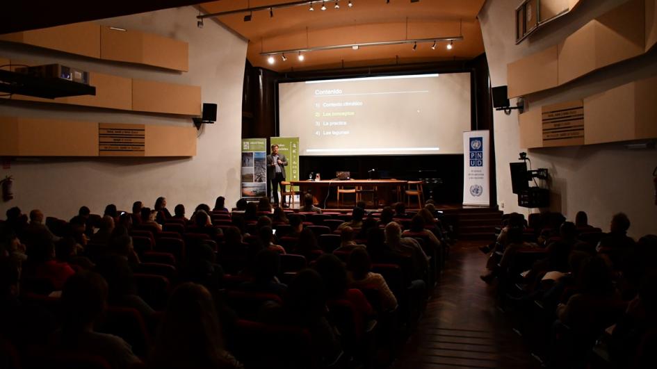 Imagen amplia donde se ve en el escenario al Freitas y todo el público presente de espaldas mirando hacia el escenario