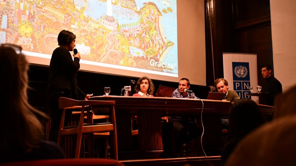 Foto de técnicos y técnicas uruguayas en el panel. Una de ellas está parada hablando