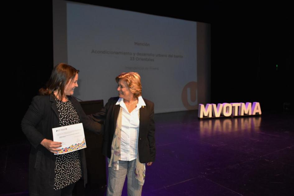 Ministra Eneida de León entrega a representa de la Intendencia de Rivera una mención en la categoría Proyectos Urbanos por el Acondicionamiento y Desarollo Urbano del Barrio 33 Orientales