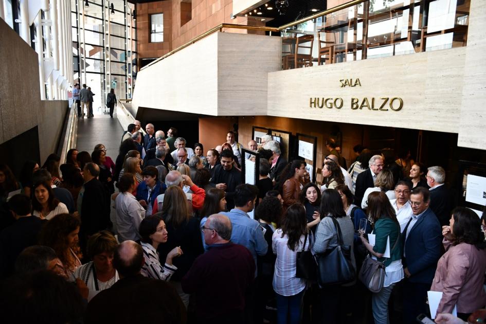 En el hall de la Hugo Balzo donde se puede ver su nombre y el público del evento brindando y viendo la muestra de los trabajos recocidos del PNU2019