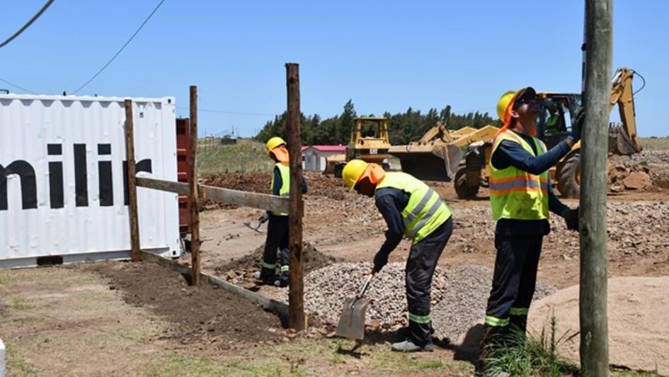 Obreros sacando escombro y atrás se ven dos retroexcavadoras en funcionamiento 