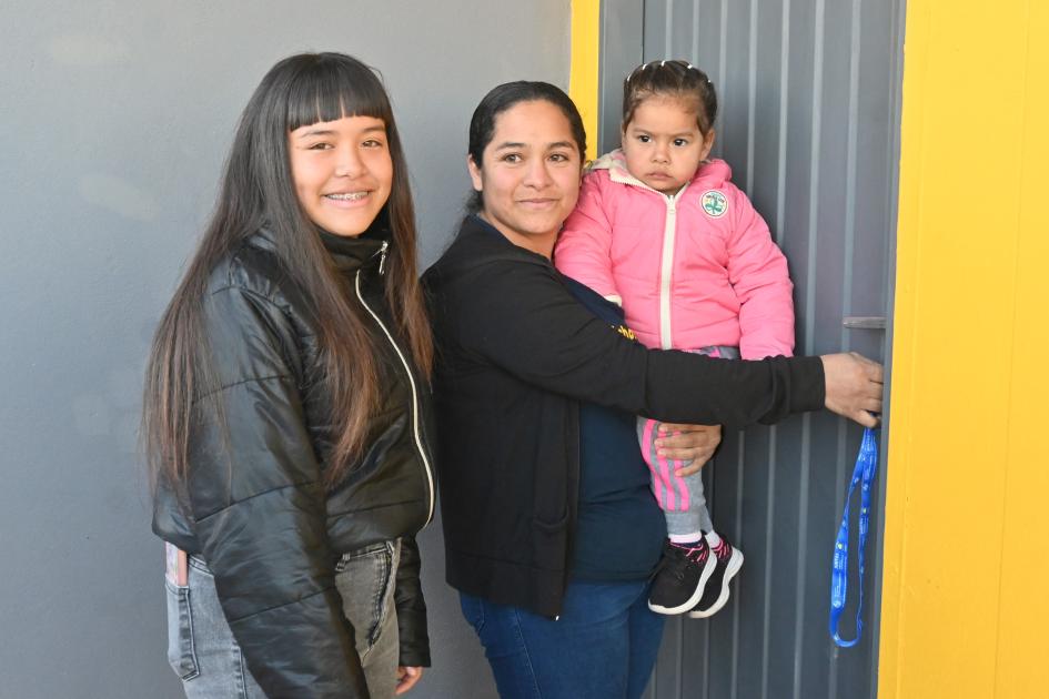 Familia participante en la entrada de su nuevo hogar