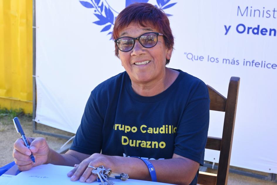 Participante de Juntos firma los documentos de su nueva vivienda 