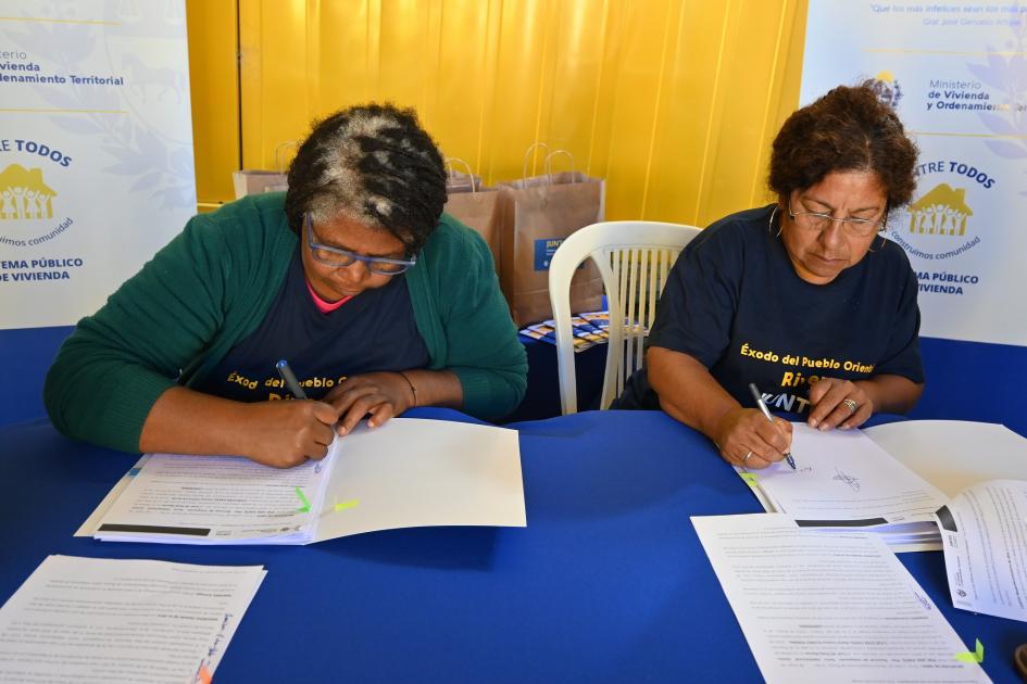 Participantes firmando los documentos de su nueva vivienda