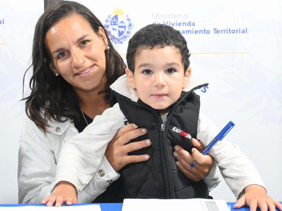 Participante de Juntos en la ceremonia de firma de documentos de su nueva vivienda