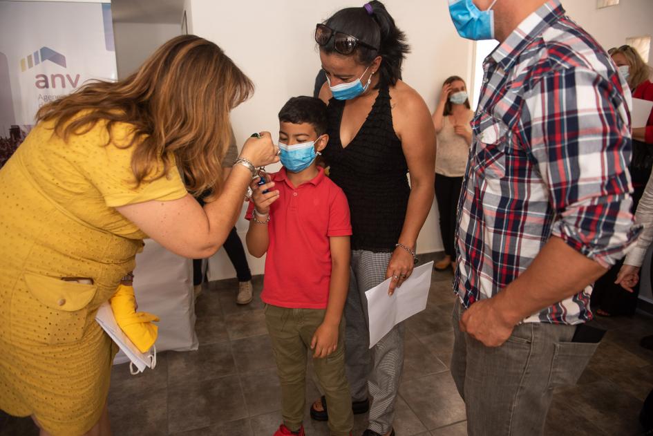 Ministra entregando una llave a un niño que esta junto a sus padres Ministra entregando una llave a un niño que esta junto a sus padres