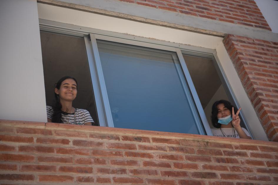 Dos beneficiarias saludando desde la ventana de su nueva vivienda Dos beneficiarias saludando desde la ventana de su nueva vivienda