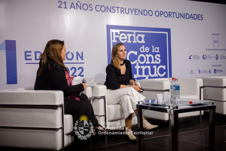 dos mujres sentadas hablando al publico