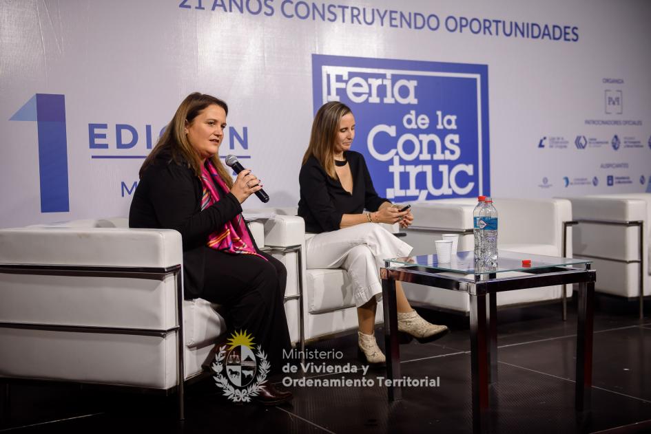 dos mujres sentadas hablando al publico