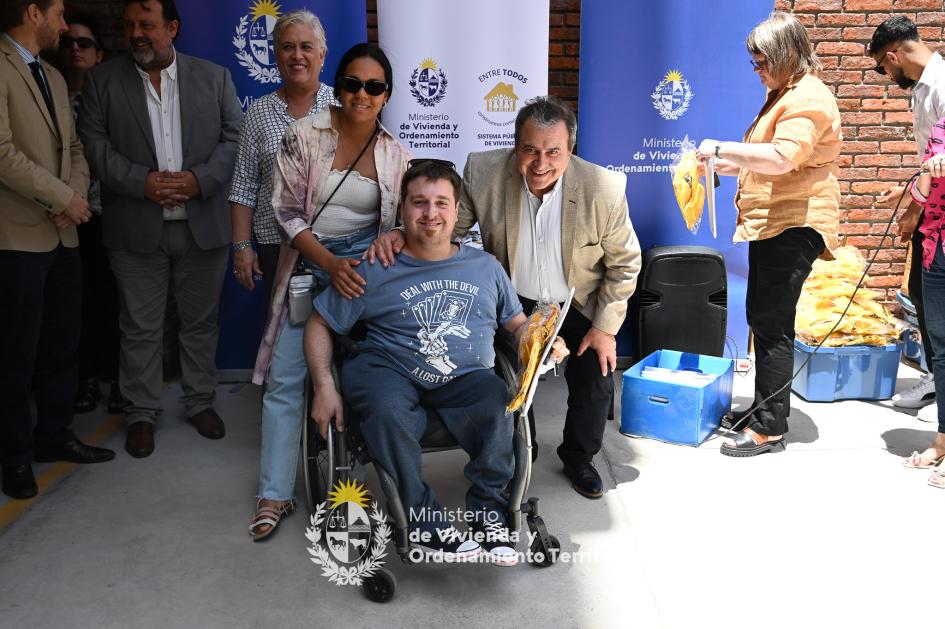 Ministro junto a nuevo propietario Ministro posando felizmente junto a nuevo propietario en silla de ruedas