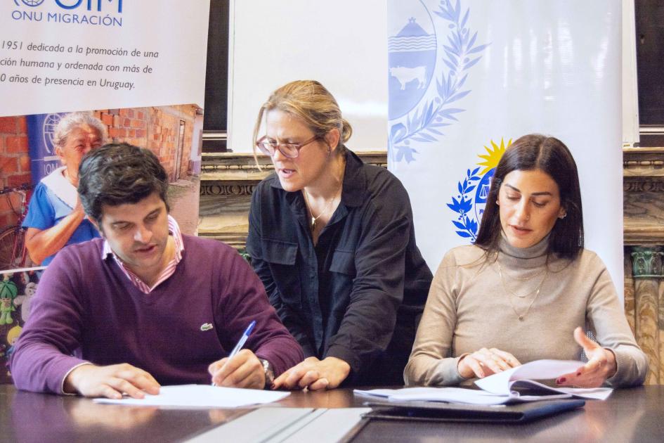 Coordinador PMB Álvaro Martínez, escribana y representante de OIM Lucia Pizzarulli Álvaro Martínez, escribana y Lucia Pizzarulli firmando