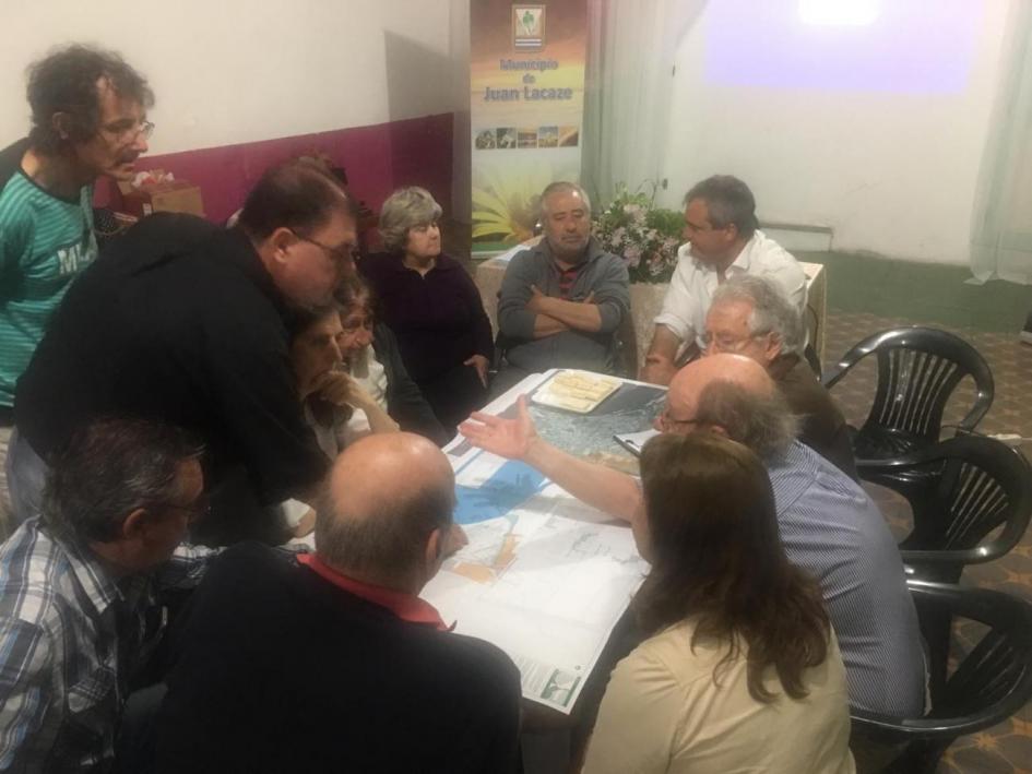 Foto de subgrupo de trabajo reunido al rededor de la mesa dialogando 