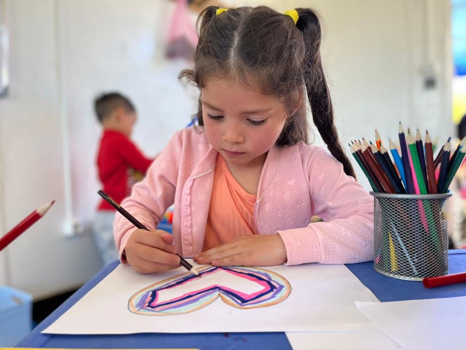 Niños de Fray Bentos juegan en el salón de usos múltiples