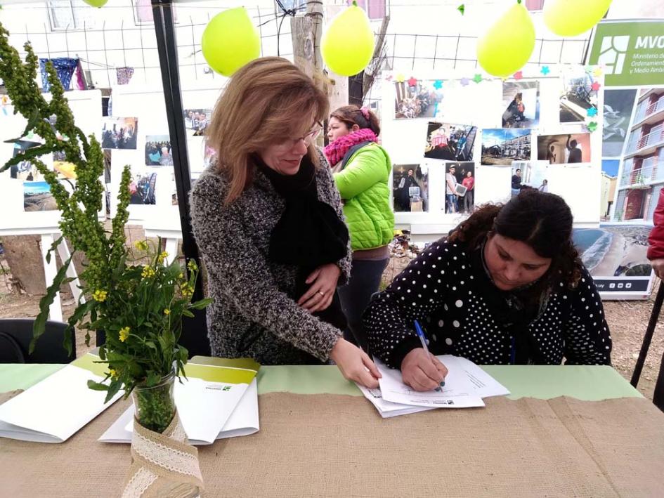 Plan Juntos inaugura viviendas en el barrio 22 de Mayo Escribana junto a una beneficiaria firmando documentación