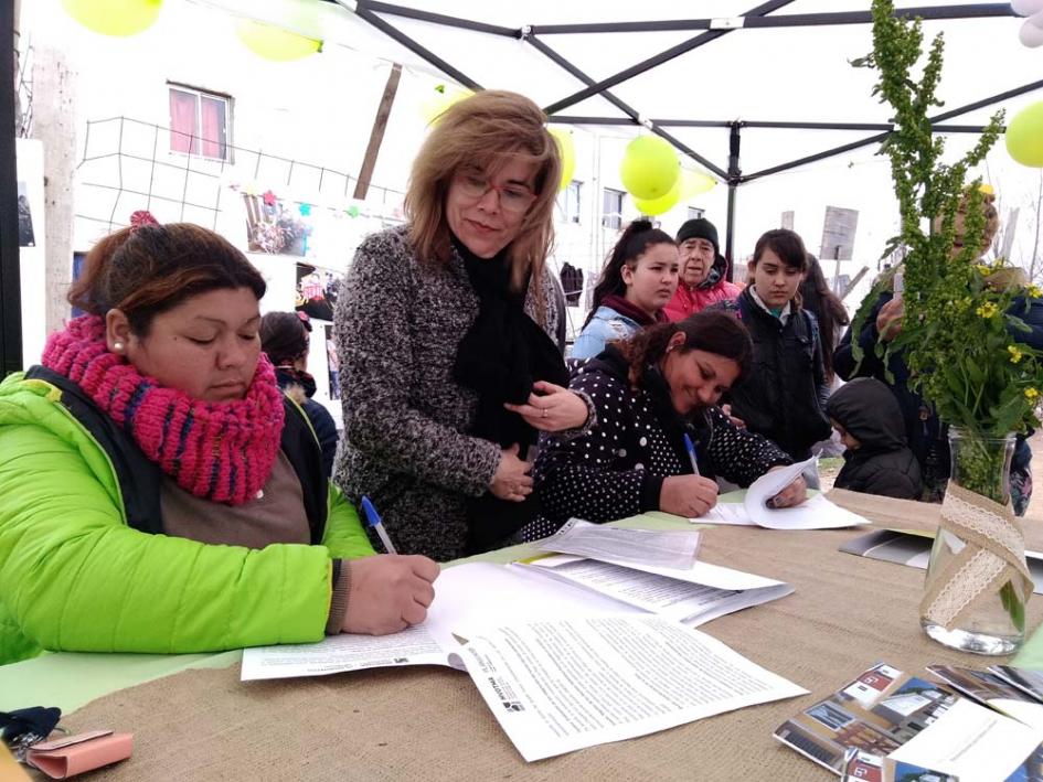 Plan Juntos inaugura viviendas en el barrio 22 de Mayo Escribana y varias familias firmando