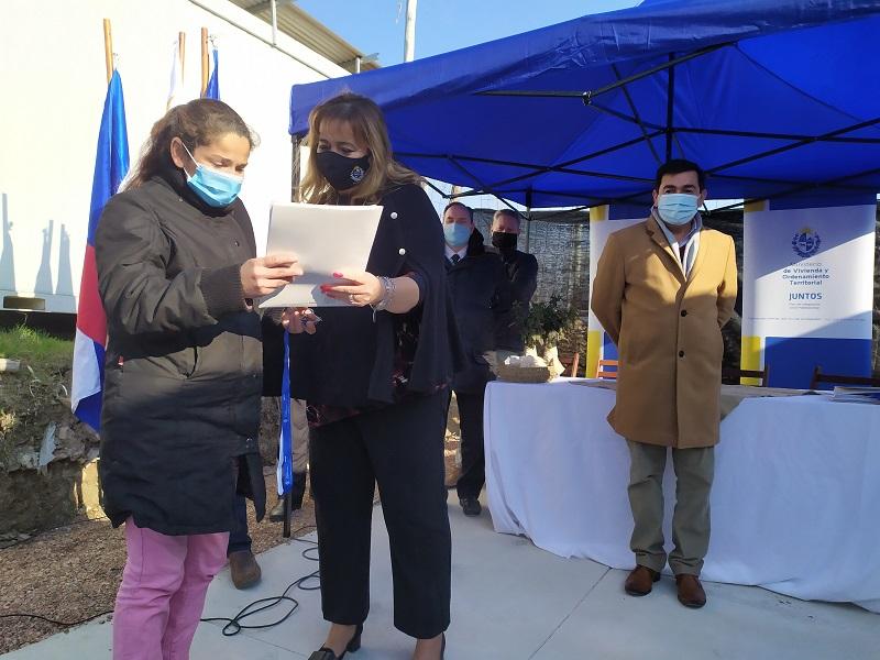 Ministra Irene Moreira entrega la documentación a una participante del barrio 6 de Diciembre en Montevideo