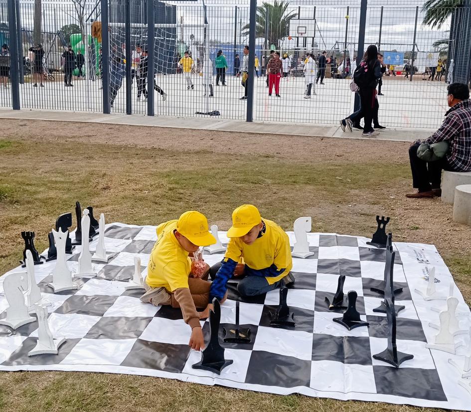 Niños jugando ajedrez Niños jugando ajedrez gigante en el piso
