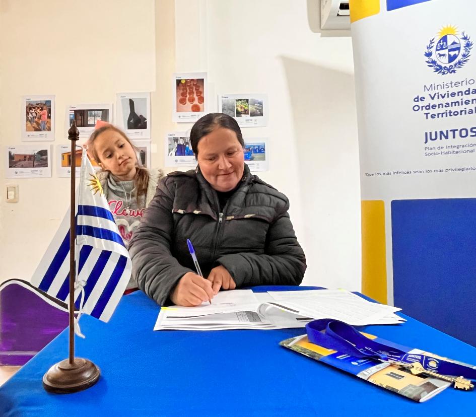 Participante de Capra firma los documentos de su nueva vivienda Participante de Capra firma los documentos de su nueva vivienda