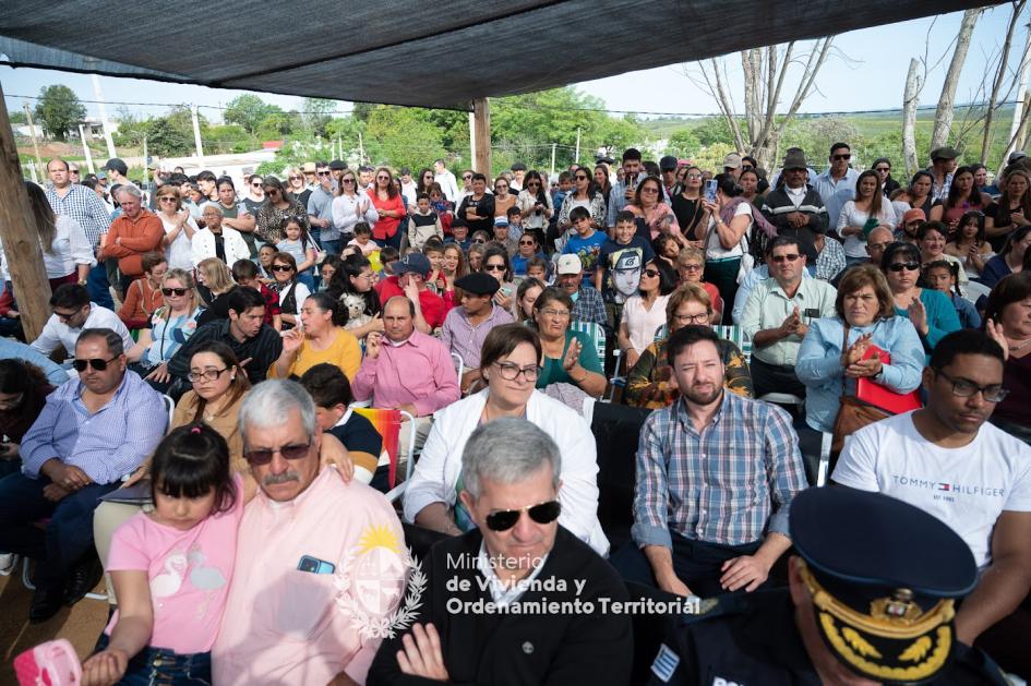 Vecinos de Minas Corrales sentados en sillas en el evento de Mevir