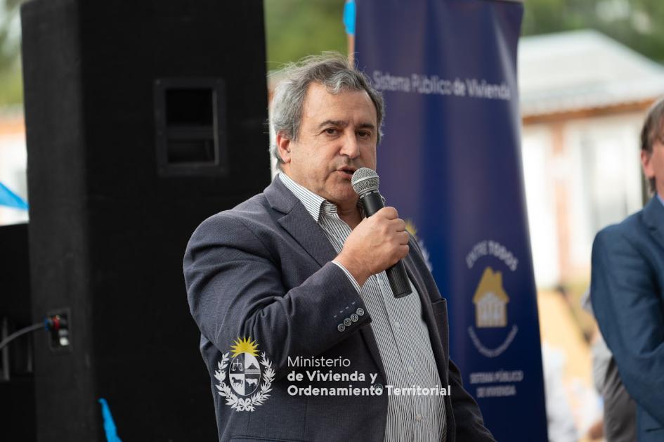 Ministro dando declaraciones en el evento Ministro de vivienda hablando con el micrófono a la gente presente