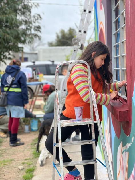 Pintura de Mural La familia del barrio ayudando a pintar el mural