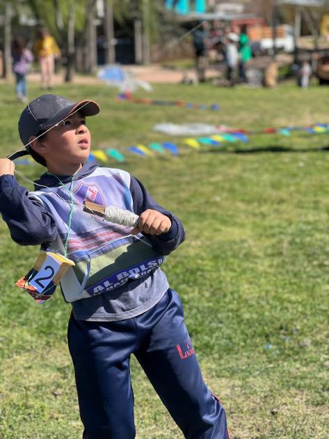 Niño con su estilo remontando una cometa. Niño remontando su cometa