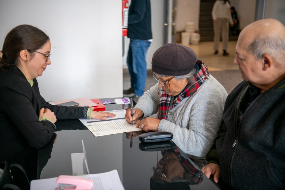 Titulaciones El Tanque - Villa Prosperidad mujer firmando el título de propiedad