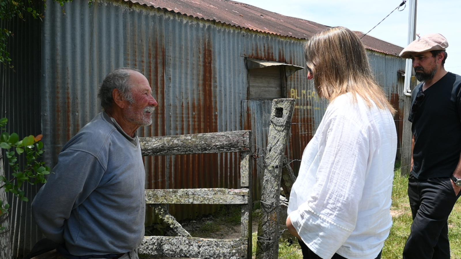 Ministra junto a vecino recorriendo el predio de su vivienda